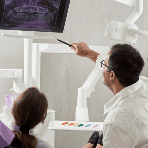 Un dentiste montre une radio à sa patiente.