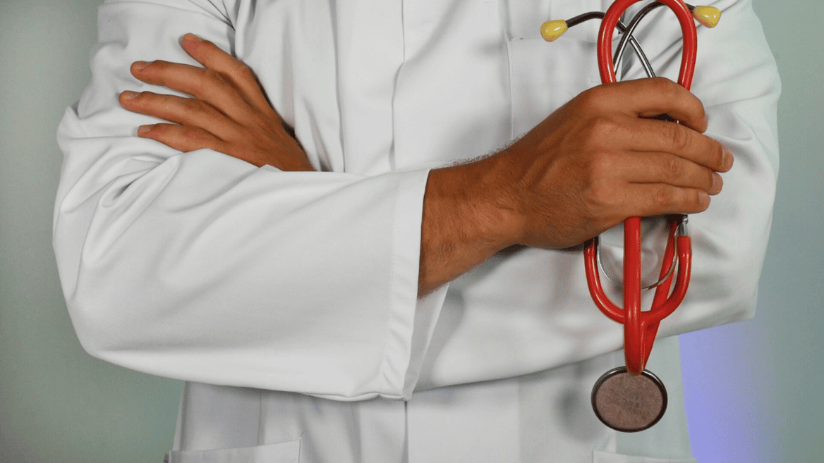 Un médecin tient un stéthoscope dans la main.