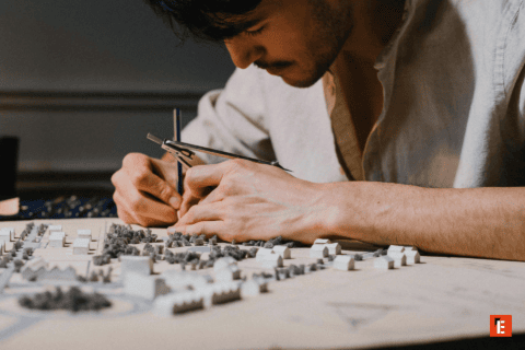 Un étudiant tenant un compas dans un cours de Design d'Espace