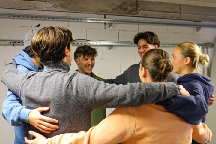 Un groupe d'étudiants se prenant par les épaules