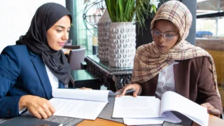 confident-female-professionals-checking-documents