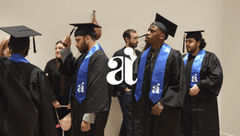 Remise de diplômes : diplômés en toges noires avec écharpes bleues.
