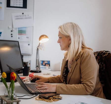 Étudiantes en travail déquipe autour dordinateurs portables devant casiers jaunes.