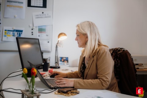 Étudiantes en travail déquipe autour dordinateurs portables devant casiers jaunes.