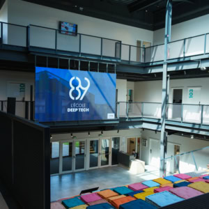 Réunion en salle 208 avec ordinateurs, participants concentrés et lumière naturelle.