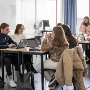 Atelier collaboratif technologie : étudiants en formation travaillant ensemble sur ordinateurs portables.