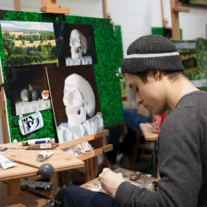 Étudiant en atelier de peinture au chevalet, étude de crâne à lhuile, pinceau et palette.