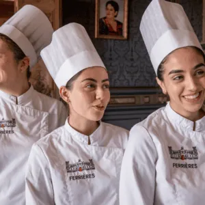 Portrait de trois chefs en toques et vestes blanches à Ferrières, ambiance historique.
