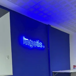 Enseigne néon bleu ingetis. sur mur bleu, coin bureau moderne.