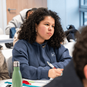 Élève concentré en classe prenant des notes pendant un cours.