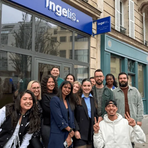 Équipe Ingetis devant le bureau, groupe souriant sur le trottoir, façade moderne.