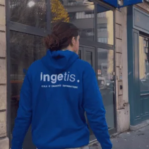 Étudiant en sweat bleu Ingetis devant lentrée de lécole dingénierie informatique.