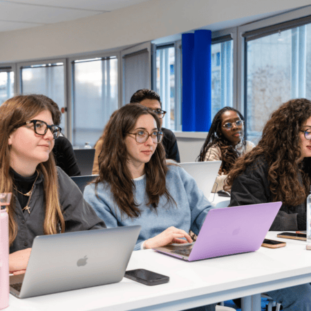 Étudiants en salle de cours utilisant ordinateurs portables lors dune formation universitaire moderne.