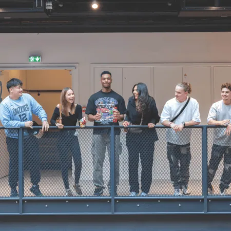 Groupe damis sur balcon intérieur industriel, détente, boissons et snacks.