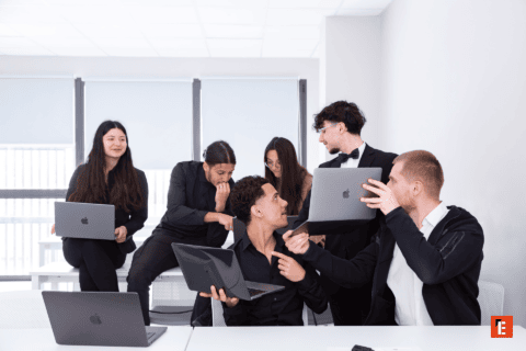 Réunion déquipe collaborative en salle lumineuse avec ordinateurs portables et brainstorming.