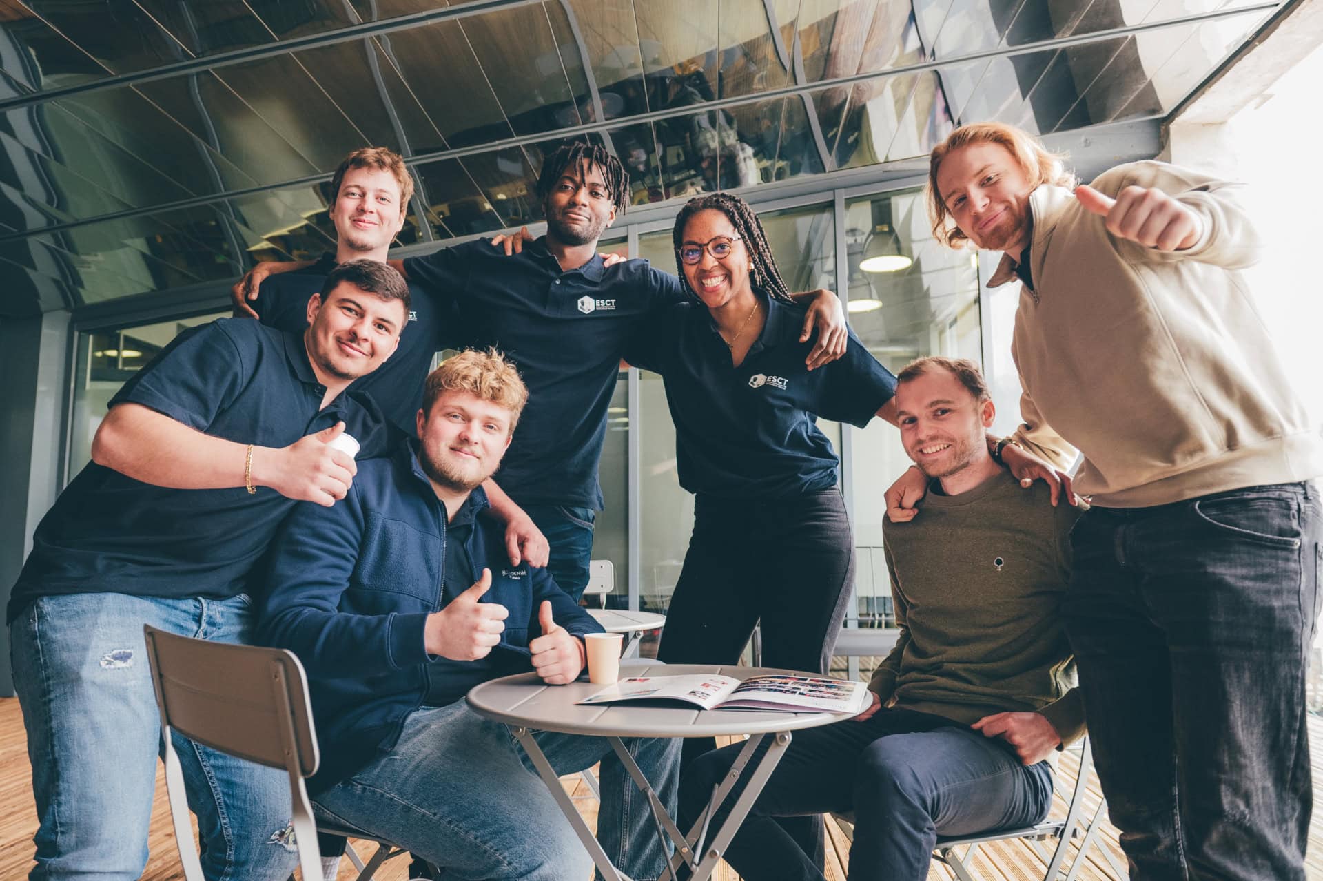 Photo déquipe de collègues souriants en espace de travail moderne, ambiance conviviale au café.