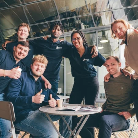 Photo déquipe de collègues souriants en espace de travail moderne, ambiance conviviale au café.