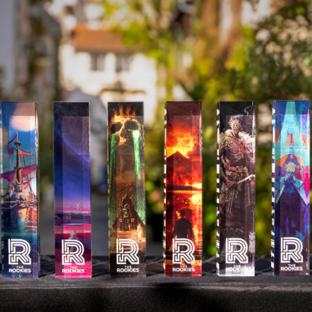 Huit trophées acryliques Rookies illustrés sur table noire, prix design et illustration.