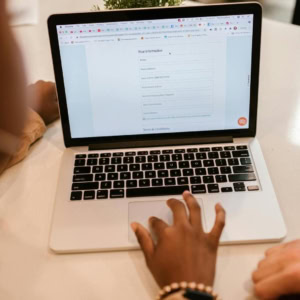 Ordinateur portable avec formulaire en ligne, mains saisissant des données lors dune consultation.
