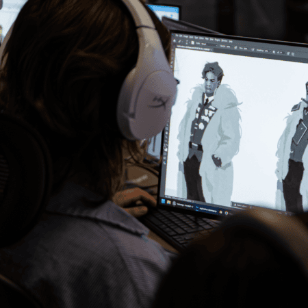 Graphiste créant un design de personnage sur écran dordinateur portable.