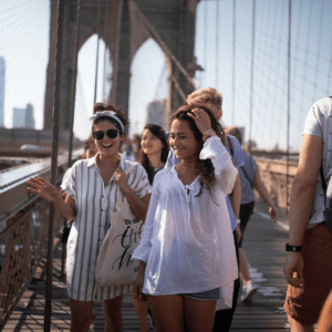 Pont suspendu animé de piétons au soleil, passerelle en bois et câbles.