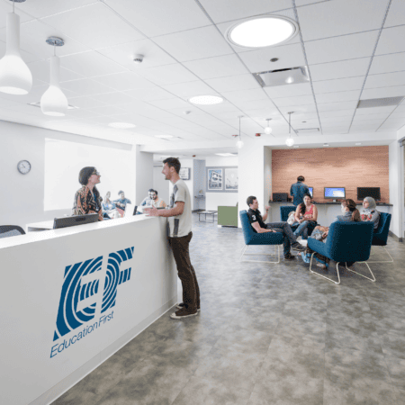 Accueil moderne pour établissement déducation, comptoir, espace lounge, chaises bleu-vert.