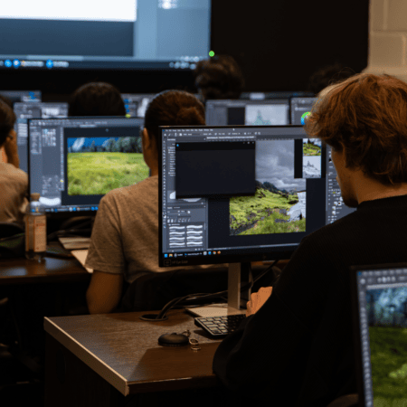 Salle informatique, cours dédition photo : étudiants sur ordinateurs retouchent paysages.