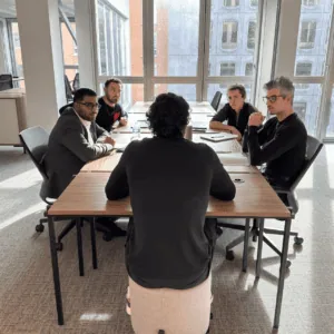 Collègues en coworking sur canapé jaune, bureau moderne, ordinateurs portables et collaboration.