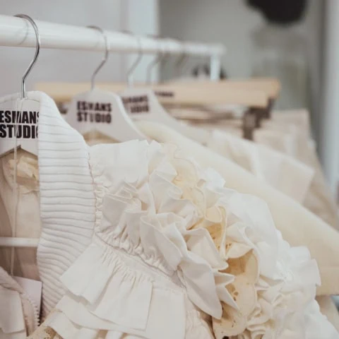 Blouse ivoire à volants et dentelle, détails couture sur cintres datelier.