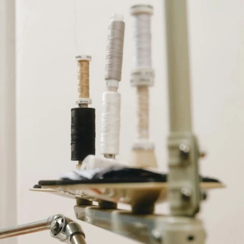 Bobines de fil sur broches de machine à coudre, matériel et atelier de couture.