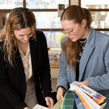 Deux designers dintérieur examinant échantillons marbre et nuanciers couleurs dans studio lumineux.