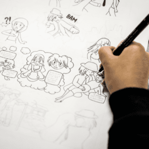 Encrage de bande dessinée style manga par une main au feutre, planche et bulles.