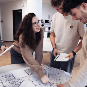 Équipe en atelier révisant plans darchitecture et design, réunion collaborative.