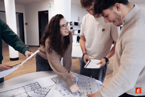 Équipe en atelier révisant plans darchitecture et design, réunion collaborative.