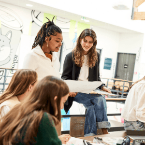 Étudiants en atelier créatif autour dune table, brainstorming et dessins dans un espace de coworking.