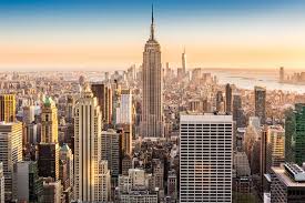 Gratte-ciel Art déco dominant une skyline urbaine au coucher de soleil.