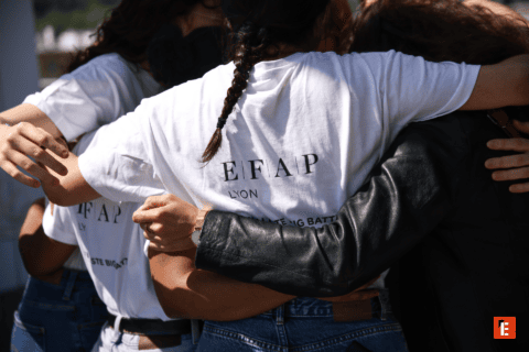 Accolade de groupe à Lyon, t‑shirts blancs et mains solidaires en gros plan.