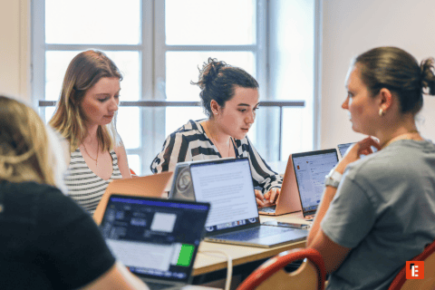 Groupe détudiants en collaboration autour dordinateurs portables pour projet de travail.