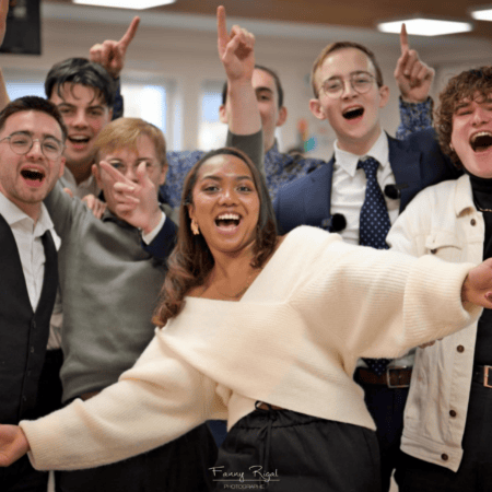 Groupe heureux de jeunes adultes riant en portrait de célébration, photo intérieure conviviale.