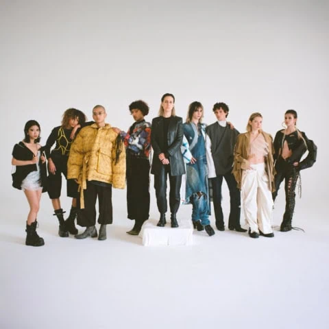 Groupe de mannequins sur fond blanc, photo mode éditorial montrant cuir, denim et textures.