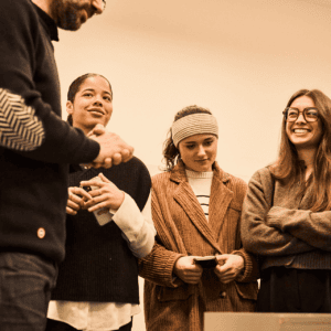 Groupe de quatre personnes en intérieur, trois femmes et un homme, ambiance chaleureuse.