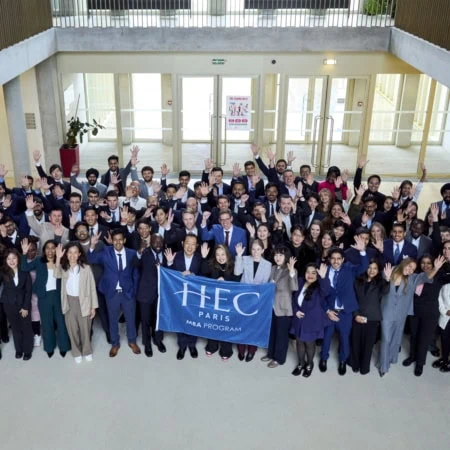 Photo de groupe HEC Paris MBA détudiants dans un atrium professionnel.