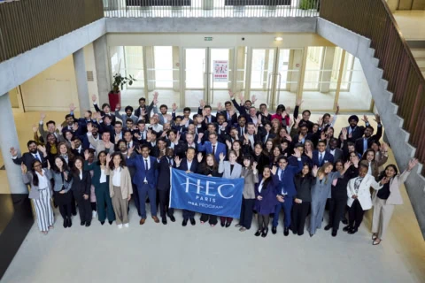 Photo de groupe HEC Paris MBA détudiants dans un atrium professionnel.