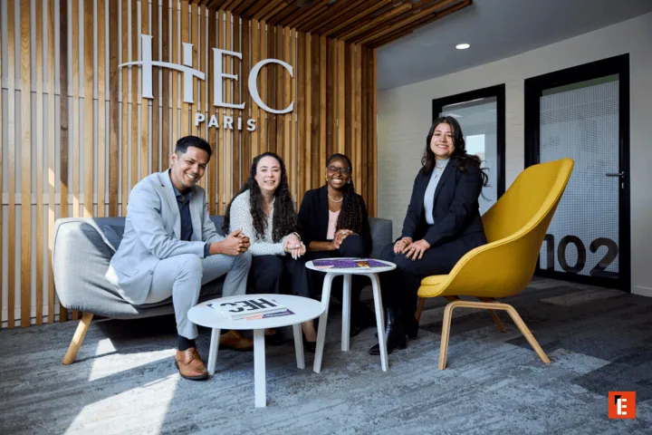Équipe HEC Paris dans salon moderne en bois, fauteuil jaune et réception lumineuse.