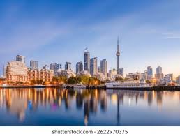 Front de mer urbain moderne avec gratte-ciel, tour dobservation et reflets sur eau calme.