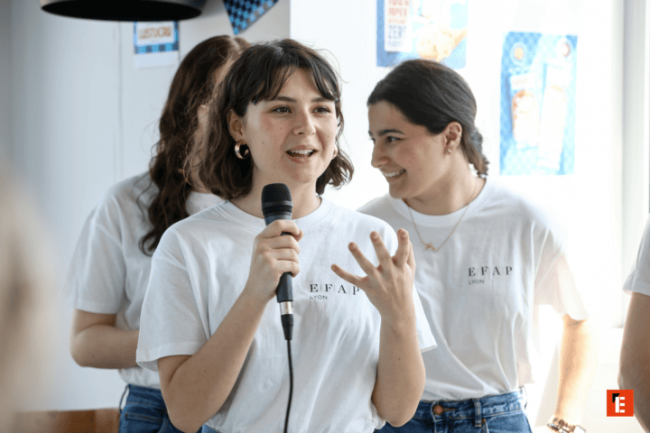 Jeune femme au micro en t‑shirt EFAP Lyon lors dun atelier.
