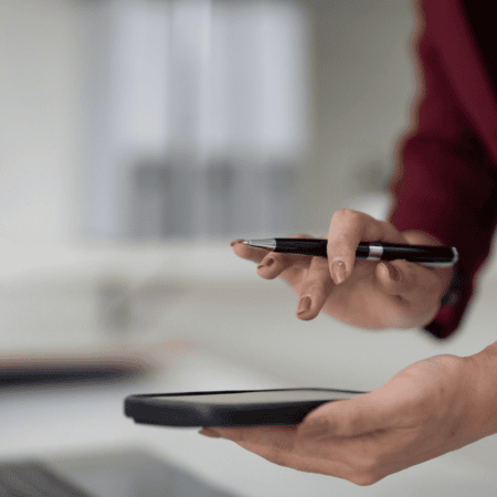 Mains professionnelles avec stylo et smartphone au-dessus dun document de bureau.