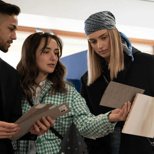 Équipe de designers examinant échantillons de matériaux, textures et couleurs en showroom.