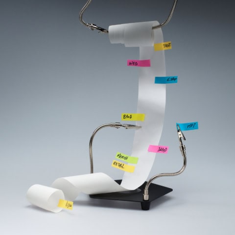 Liste déroulante avec post-it colorés, bras métalliques et base noire, concept organisation marketing.