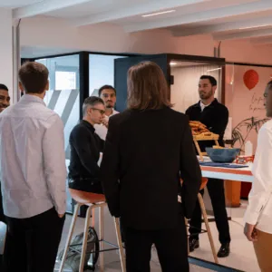 Pause café en open space : collègues discutant autour de viennoiseries dans un espace détente.